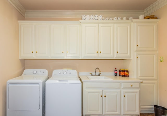 laundry area with separate washer and dryer, cabinet space, ornamental molding, and a sink
