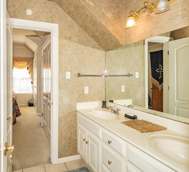 full bathroom featuring a sink, double vanity, tile patterned floors, and wallpapered walls