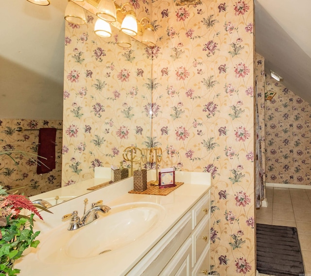 bathroom with wallpapered walls, vanity, baseboards, and tile patterned flooring