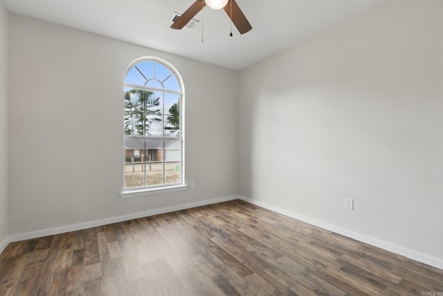 spare room with plenty of natural light, baseboards, and wood finished floors