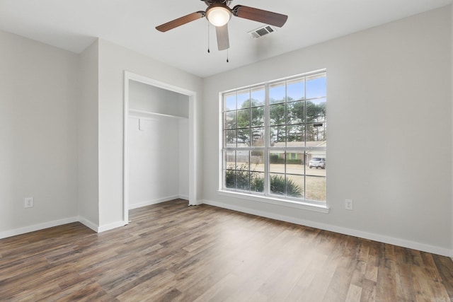 unfurnished bedroom with a closet, wood finished floors, and baseboards