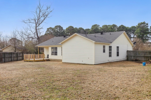 back of house featuring fence, a deck, and a yard