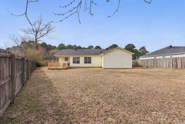 back of house featuring a deck, a yard, and a fenced backyard