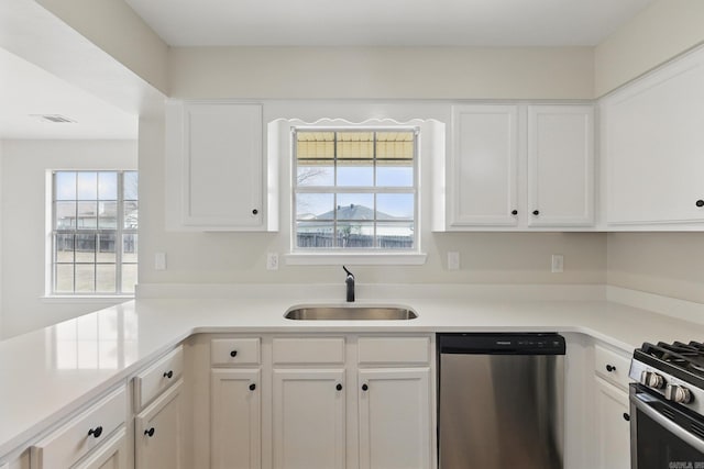 kitchen featuring light countertops, visible vents, appliances with stainless steel finishes, white cabinetry, and a sink