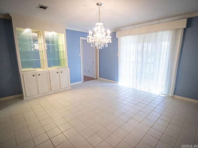 unfurnished room with light tile patterned floors, visible vents, ornamental molding, a textured ceiling, and baseboards