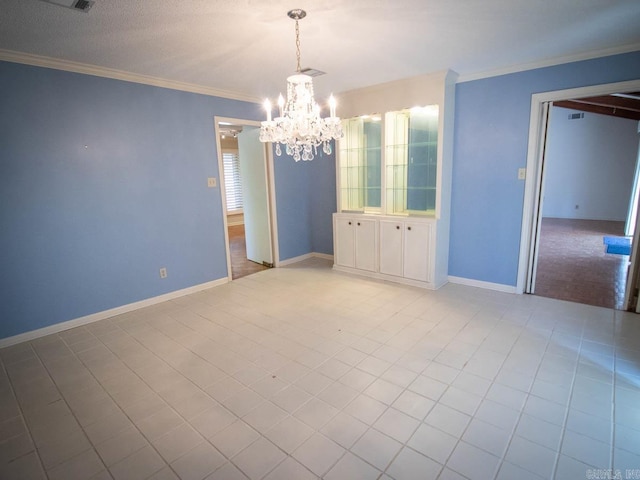 unfurnished dining area with ornamental molding, a notable chandelier, a textured ceiling, and baseboards