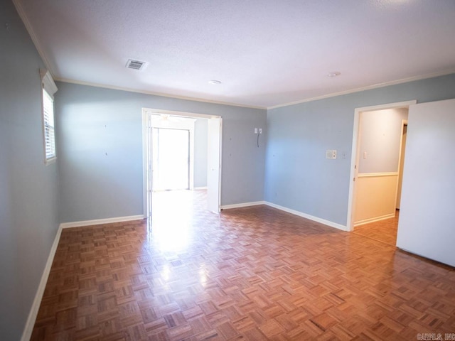 unfurnished room with crown molding, visible vents, and baseboards