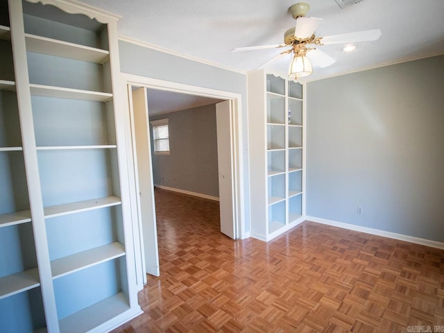 unfurnished room featuring a ceiling fan, crown molding, and baseboards