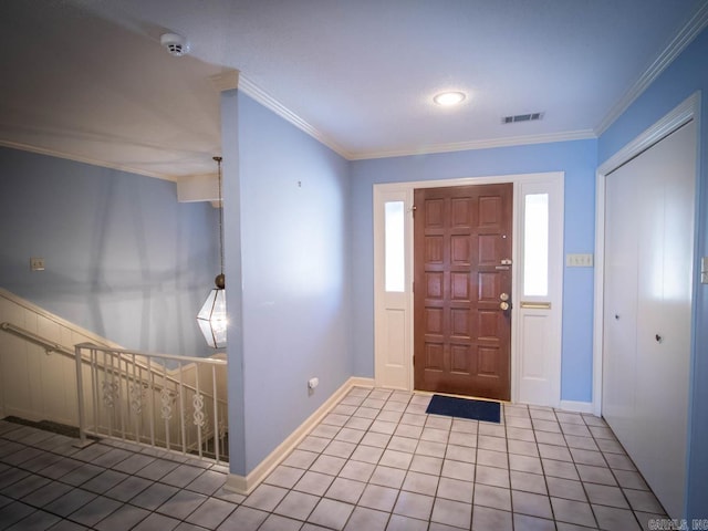 tiled foyer featuring baseboards, visible vents, and crown molding