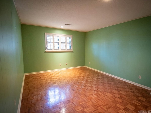 spare room featuring baseboards, visible vents, and a textured ceiling