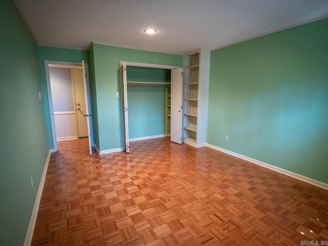 unfurnished bedroom with crown molding, baseboards, and a closet