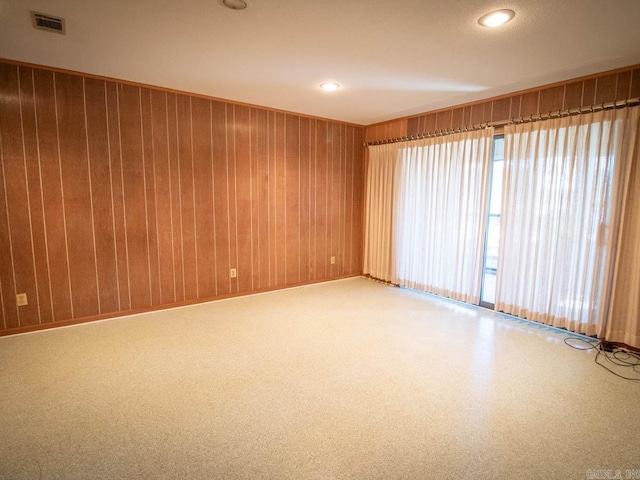 unfurnished room with recessed lighting, visible vents, and wooden walls