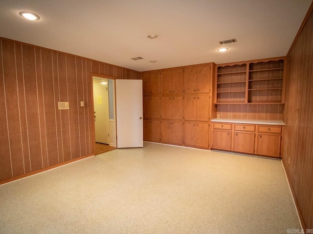 unfurnished room with wooden walls and visible vents