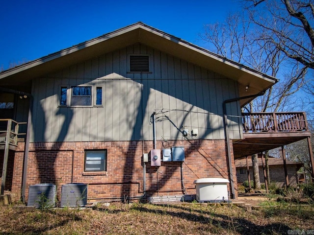 view of property exterior featuring cooling unit and brick siding