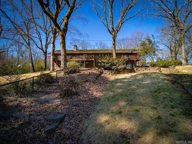 exterior space featuring fence, a deck, and a lawn