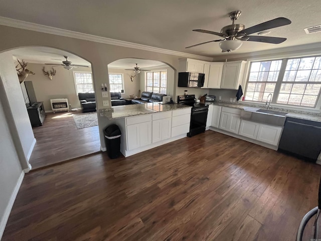 kitchen featuring electric range, visible vents, stainless steel microwave, open floor plan, and a peninsula