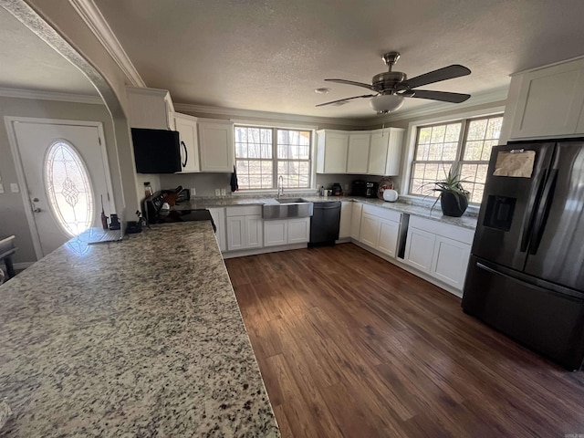 kitchen with ornamental molding, dark wood-type flooring, a textured ceiling, black appliances, and a sink