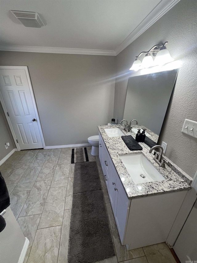 bathroom with double vanity, crown molding, visible vents, and a sink