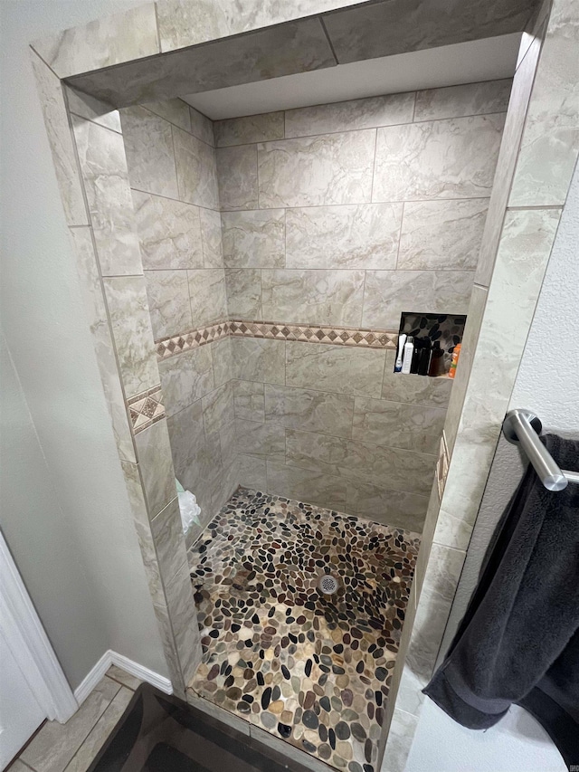 bathroom featuring a shower stall and baseboards