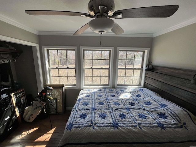 bedroom featuring a ceiling fan, crown molding, and wood finished floors