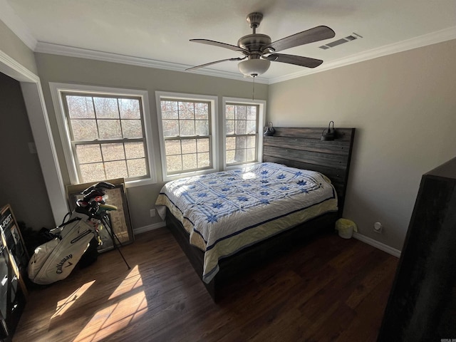 bedroom with multiple windows, dark wood finished floors, visible vents, and crown molding