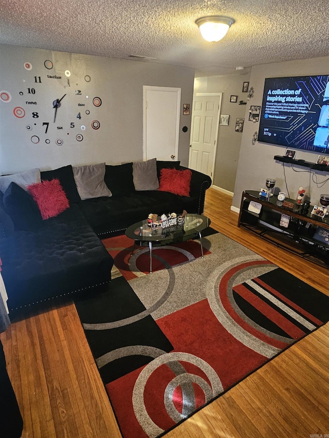 living area with a textured ceiling and wood finished floors