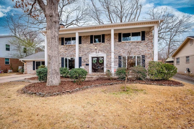 neoclassical / greek revival house featuring brick siding and a front lawn