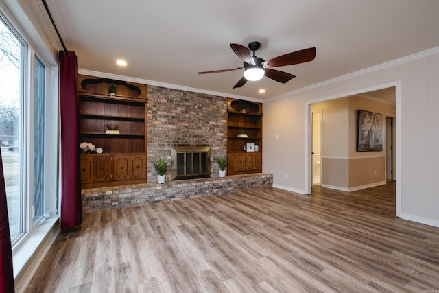 unfurnished living room with a fireplace, built in features, wood finished floors, and ornamental molding