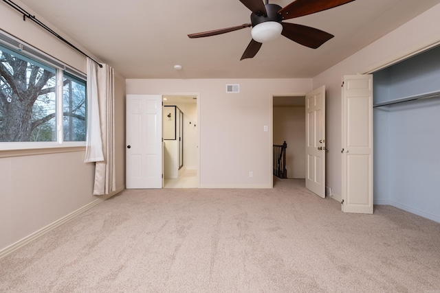 unfurnished bedroom featuring light carpet, baseboards, visible vents, and a ceiling fan