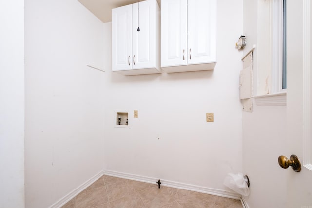 clothes washing area with cabinet space, baseboards, and washer hookup