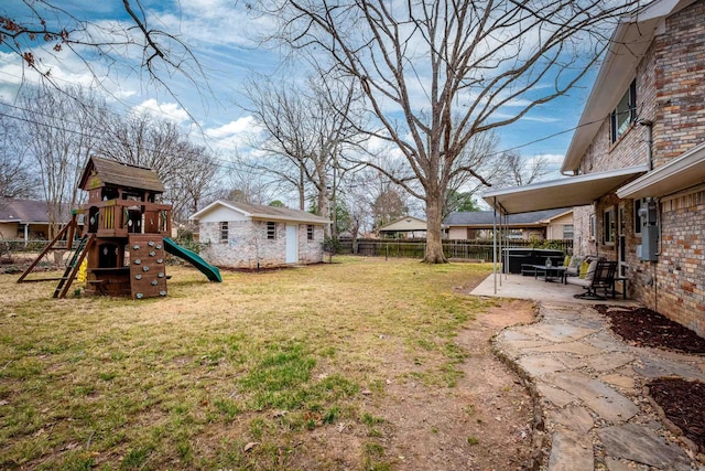 view of yard featuring a patio area, a fenced backyard, and a playground