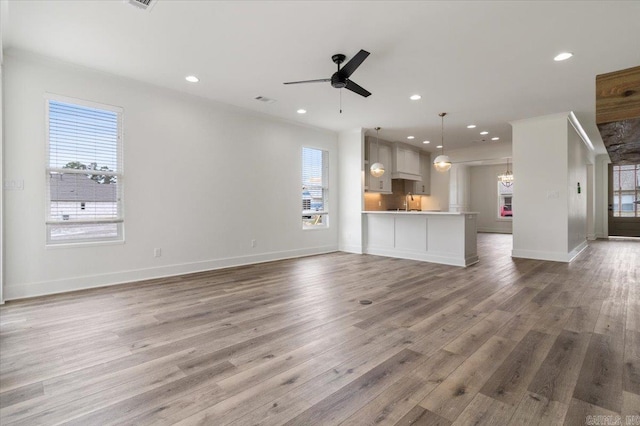 unfurnished living room featuring recessed lighting, wood finished floors, visible vents, baseboards, and a ceiling fan