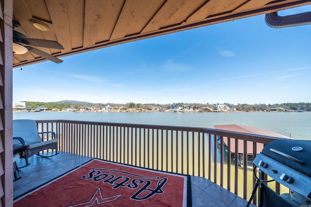 exterior space with area for grilling, a ceiling fan, and a water view