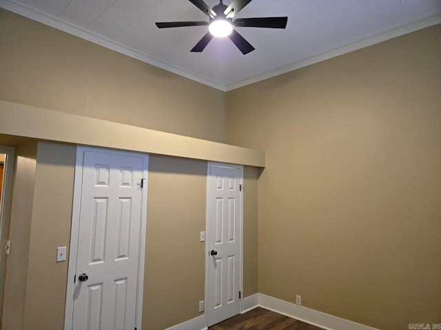 interior space featuring baseboards, dark wood finished floors, a ceiling fan, and crown molding