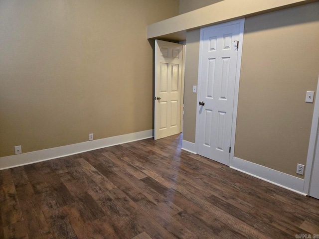 unfurnished room featuring dark wood finished floors and baseboards