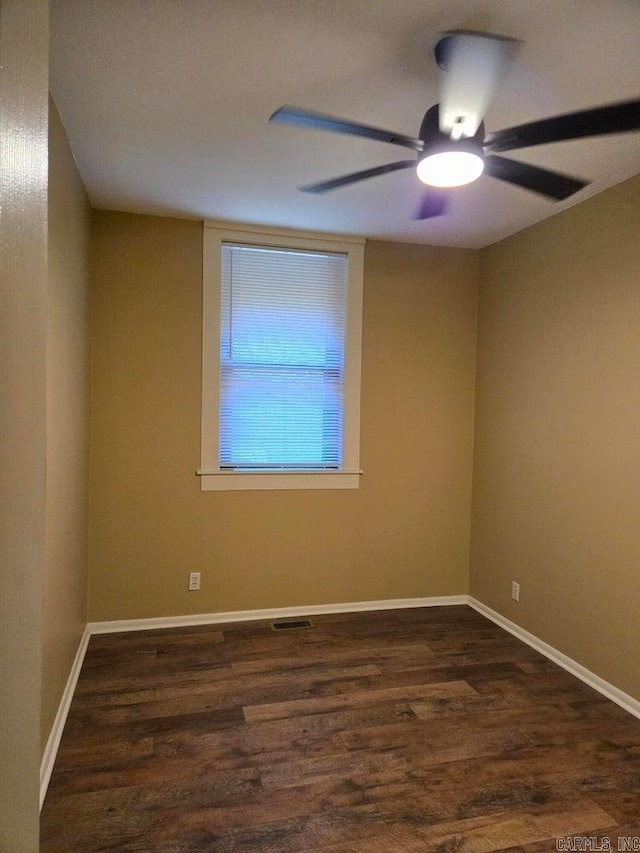 empty room with ceiling fan, wood finished floors, visible vents, and baseboards