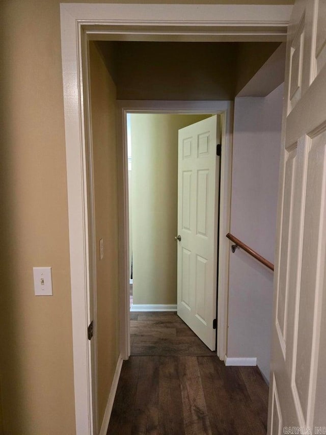 hallway with dark wood-type flooring and baseboards