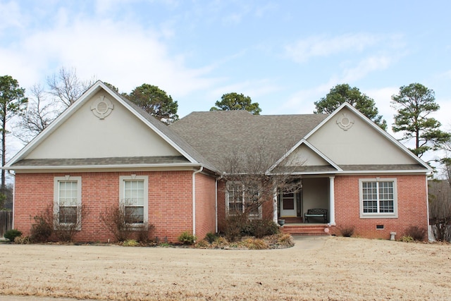 view of front facade featuring crawl space, covered porch, roof with shingles, and brick siding