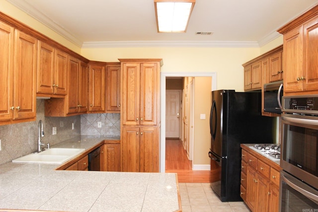 kitchen featuring visible vents, ornamental molding, a sink, black appliances, and backsplash