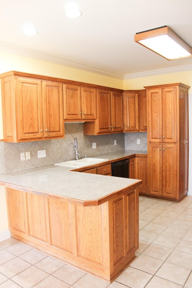 kitchen with a peninsula, black dishwasher, light countertops, and backsplash