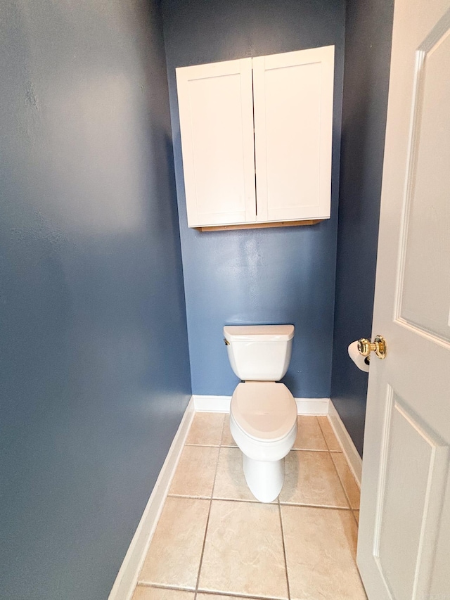 bathroom featuring tile patterned flooring, toilet, and baseboards