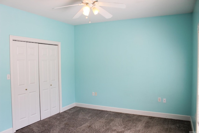 unfurnished bedroom featuring dark colored carpet, a closet, a ceiling fan, and baseboards