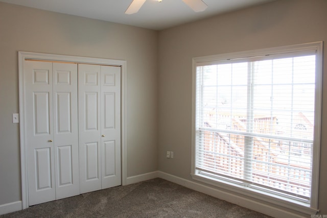 unfurnished bedroom featuring carpet floors, a closet, multiple windows, and ceiling fan