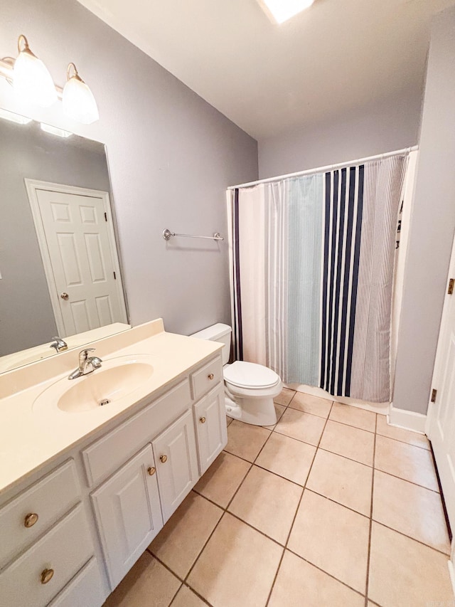 full bath featuring toilet, vanity, and tile patterned floors