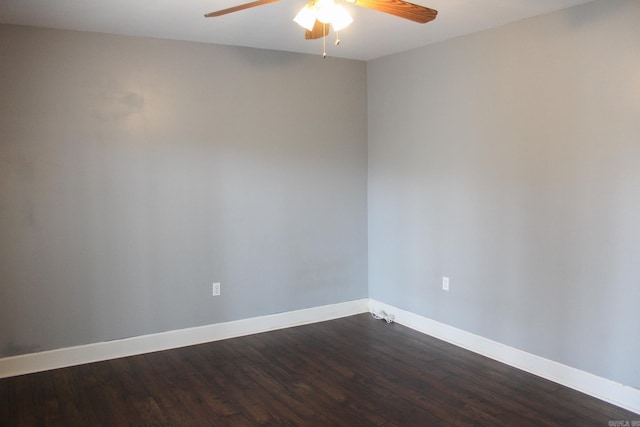 unfurnished room with dark wood-style flooring, a ceiling fan, and baseboards