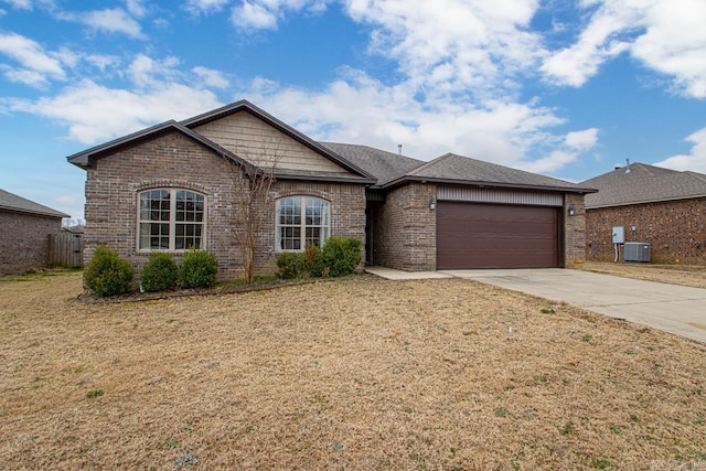 single story home with a garage, a shingled roof, brick siding, driveway, and a front lawn