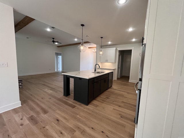 kitchen featuring white cabinetry, open floor plan, a sink, and recessed lighting