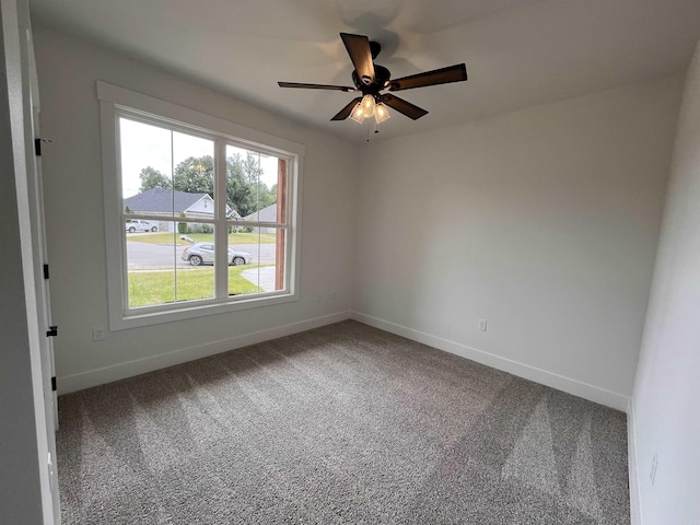 empty room featuring ceiling fan, carpet, and baseboards