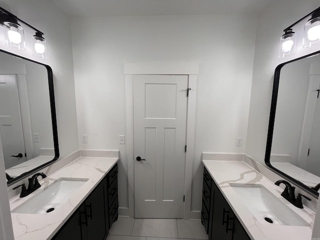 bathroom featuring marble finish floor, two vanities, and a sink