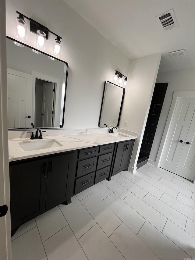 full bathroom with double vanity, visible vents, and a sink